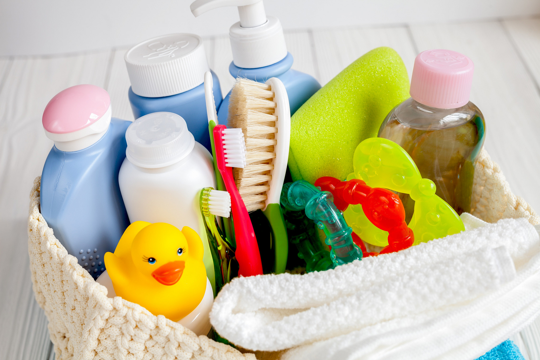 Various commodities in a basket (shampoo, toothbrush, toys)